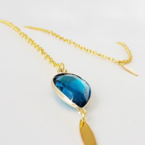 collier de dos chaine dorée et pendentif goutte de verre à facette bleu lagon