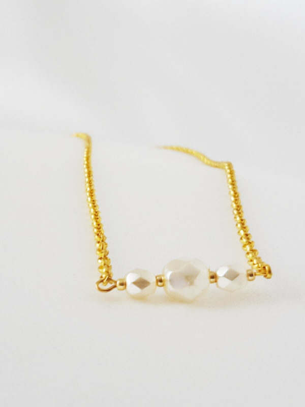 collier de dos chaine dorée et perles à facettes crème clair